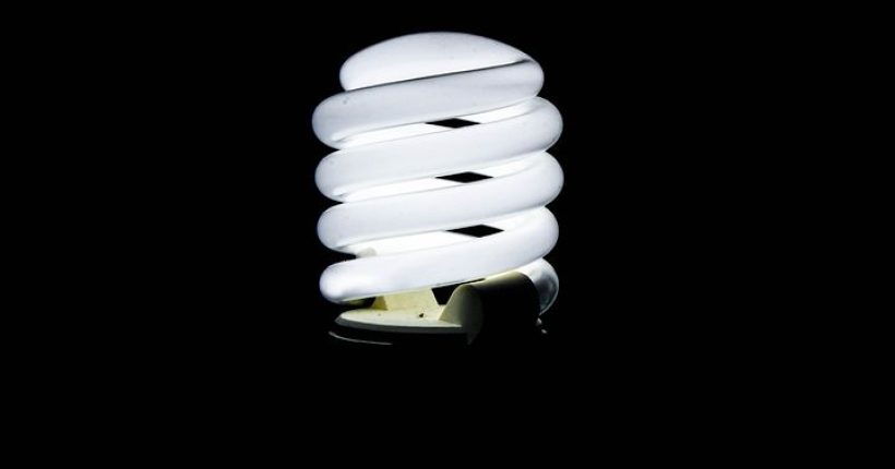 Energiesparlampe vor schwarzem Hintergrund